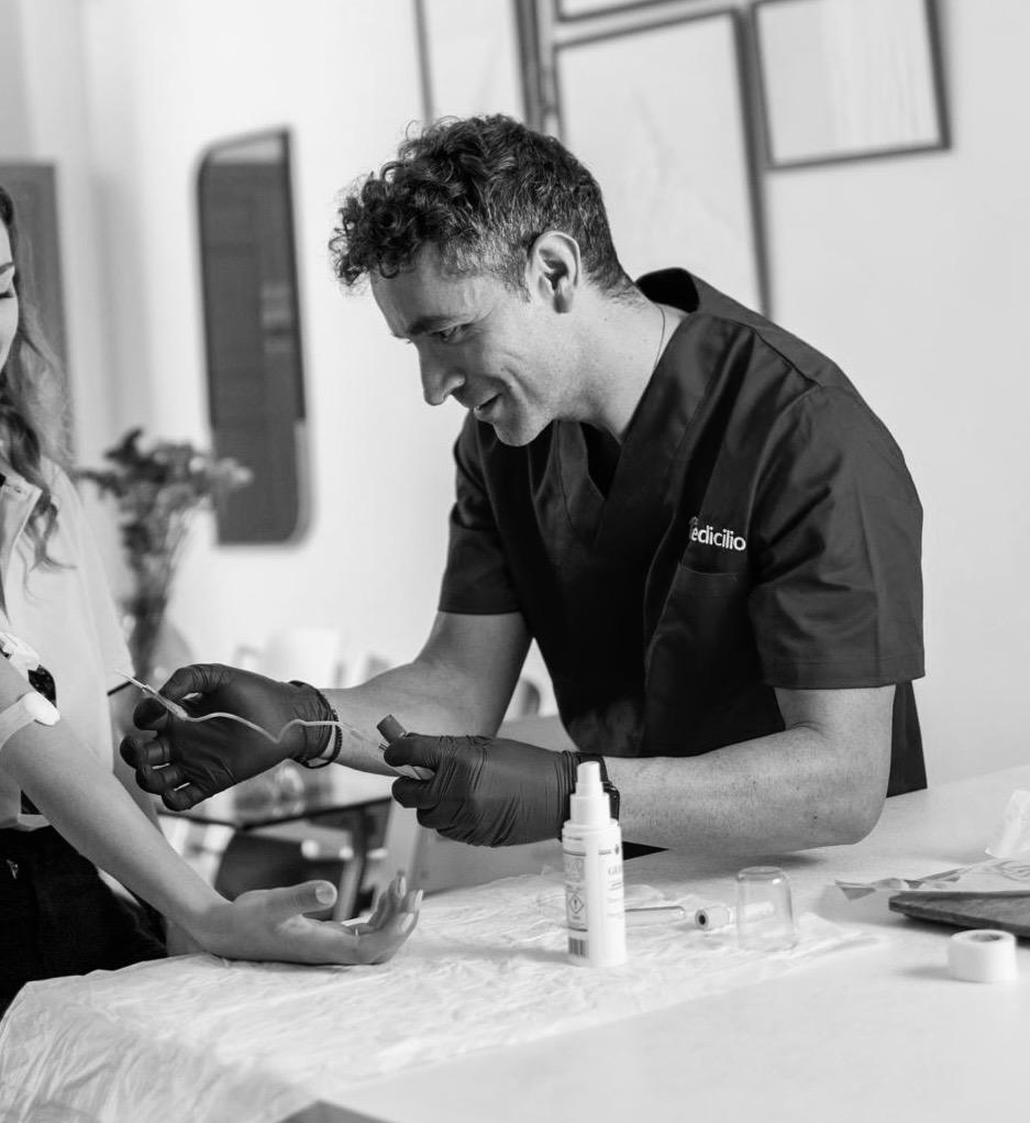 Francesco Rotta durante una prestazione infermieristica in studio, con guanti e materiale sterile